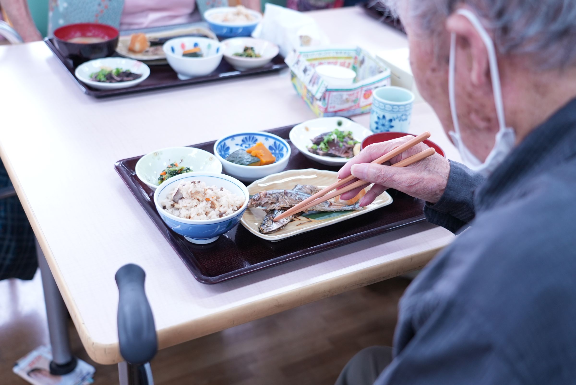 秋の味覚・さんま御膳を前に、食事の時間を待つお客様の後ろ姿