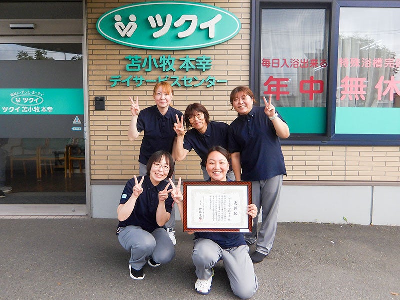 表彰状を持つ須田さんと、ツクイ苫小牧本幸の皆さん