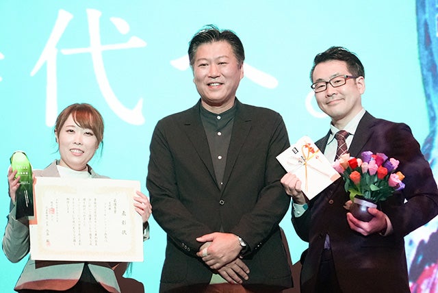 最優秀賞受賞の様子　高畠社長を囲む霜鳥さん（写真左）と施設長の伊澤さん（写真右）